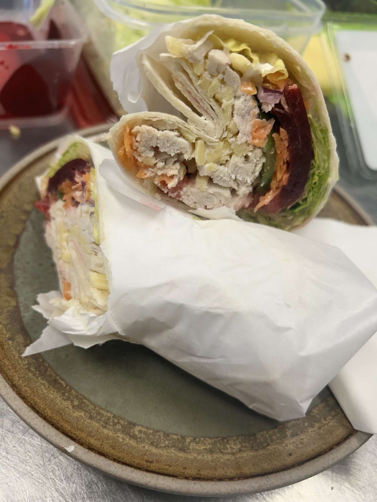 Chicken and salad wraps cut in half and wrapped in paper